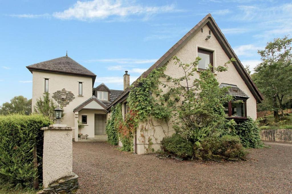 a large white house with a driveway at 1 Bed Lodge - Sleeps 2 - Parking - Wifi in Acharacle