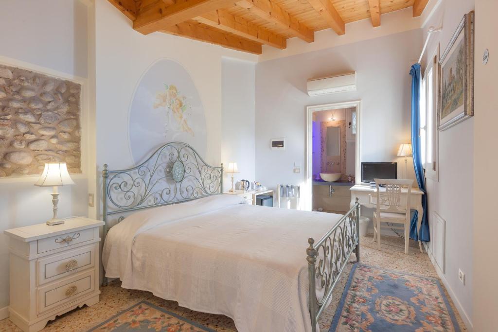 a bedroom with a large bed and a desk at Talamo Rooms in San Martino Buon Albergo