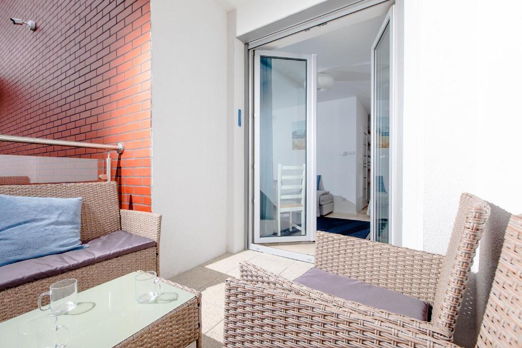 balkon ze stołem i krzesłami oraz oknem w obiekcie Resort Apartamenty Klifowa Rewal 71 w Rewalu