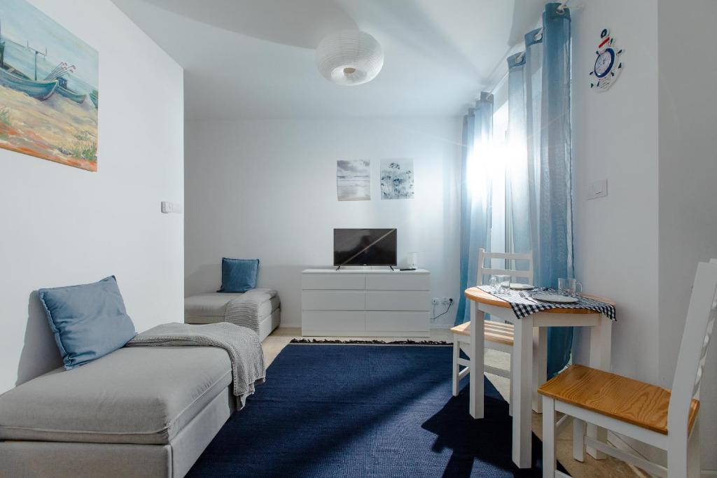 salon z kanapą i telewizorem w obiekcie Resort Apartamenty Klifowa Rewal 71 w Rewalu