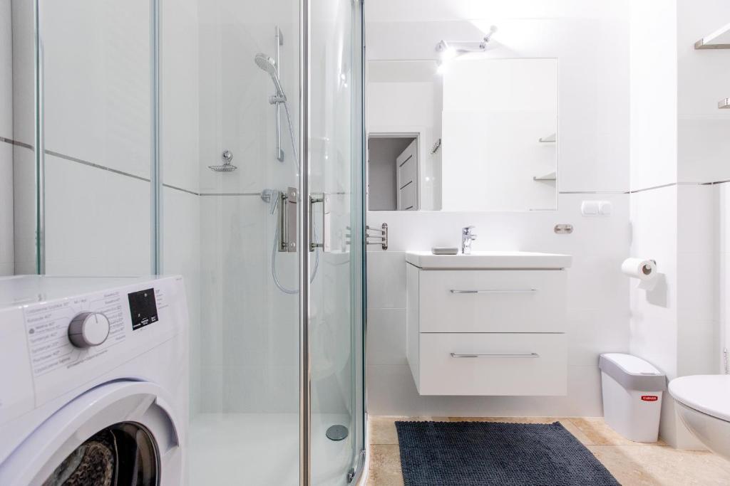 biała łazienka z pralką i umywalką w obiekcie Resort Apartamenty Klifowa Rewal 71 w Rewalu