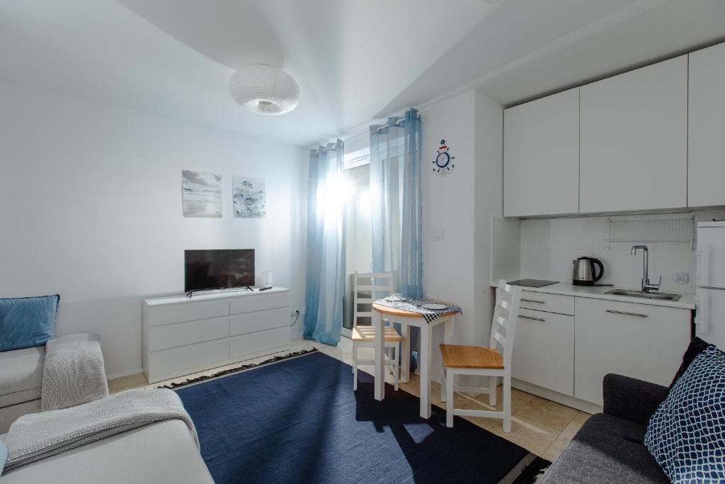 kuchnia i salon z kanapą i stołem w obiekcie Resort Apartamenty Klifowa Rewal 71 w Rewalu
