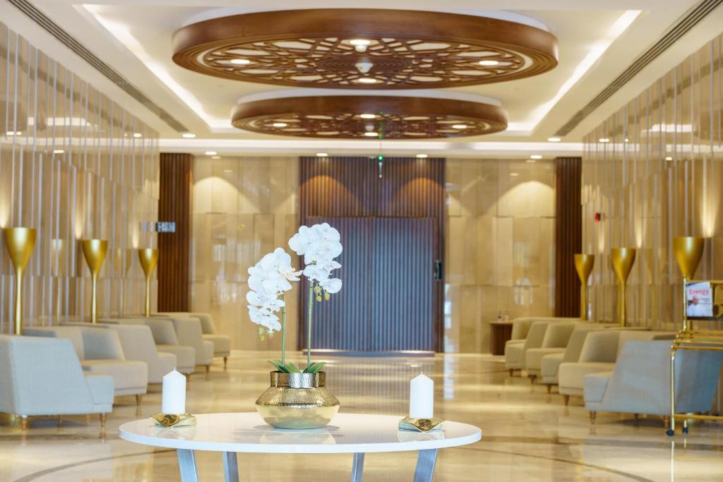 a lobby with a table with flowers on it at Radisson Hotel Muscat Panorama in Muscat