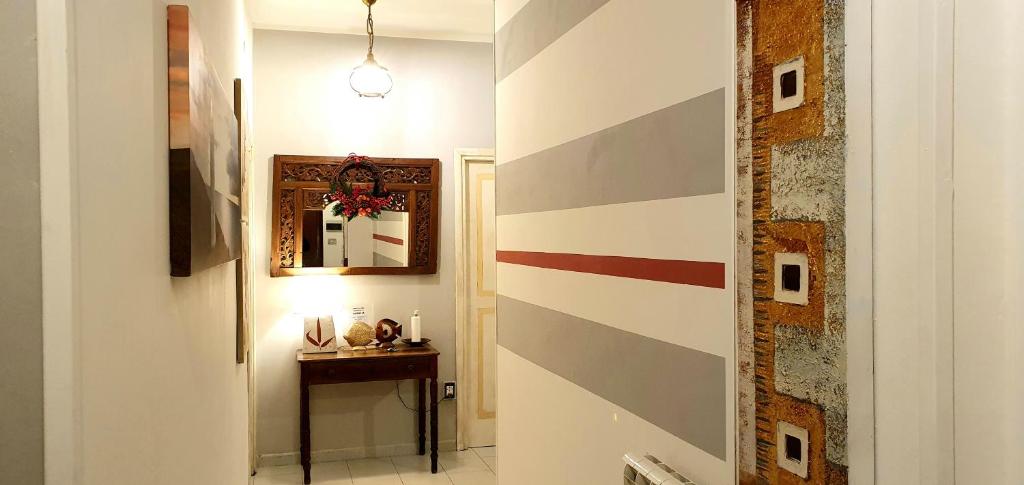 a hallway with a striped wall with a table and a mirror at COMODO AL MARE in Lerici