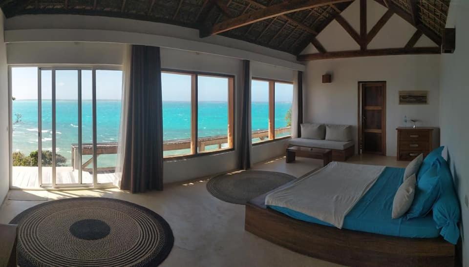 a bedroom with a bed with a view of the ocean at Mazava Loha Resort in Diego Suarez