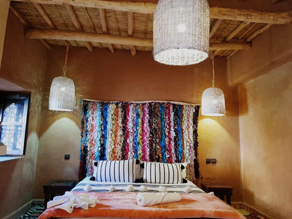 a bedroom with a bed with a curtain and two lights at Dar Isselday in Tisselday