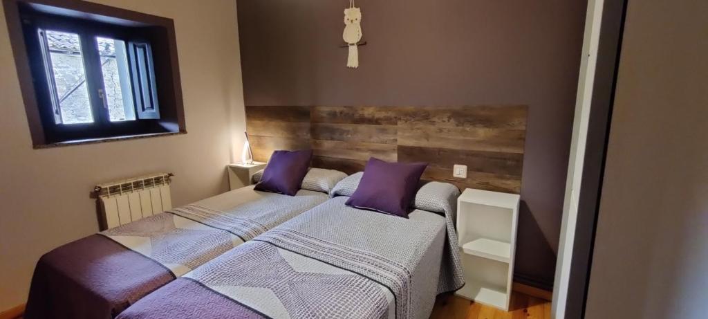a bedroom with two beds with purple pillows at Vivienda Vacacional Ángel Inguanzo in Inguanzo