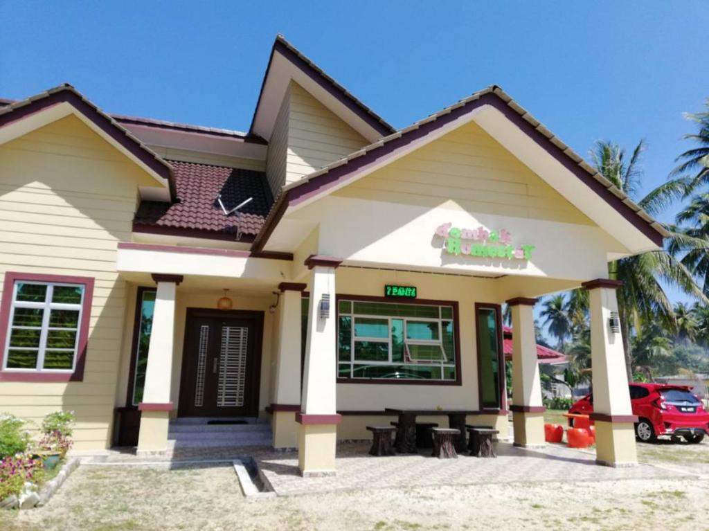 a house with a car parked in front of it at D'Ombak Homestay Pantai Baru in Bachok