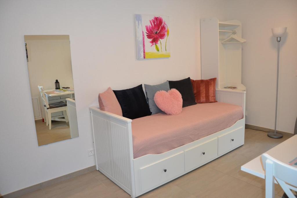 a bedroom with a white bed with a heart pillow at Studio Doux rayon in Lausanne