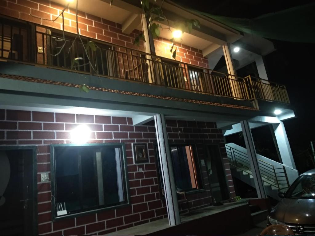 um edifício de tijolos com uma varanda em cima em Aamantran Residency em Dapoli