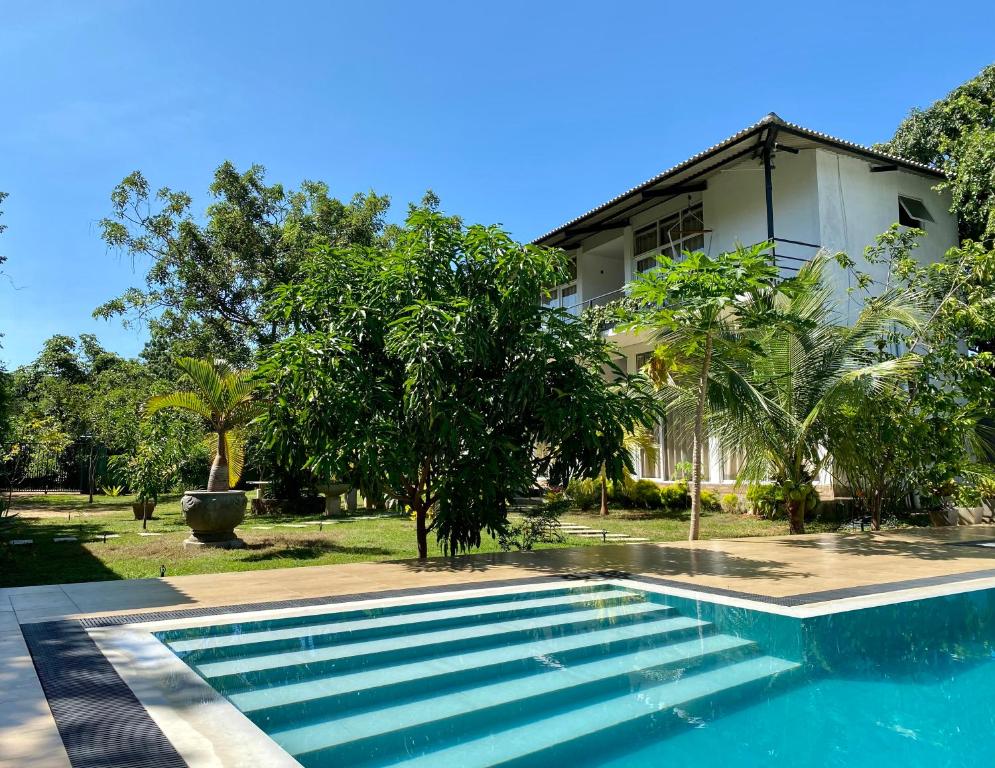 a swimming pool in front of a house at Sapphire Garden Hotel in Habarana