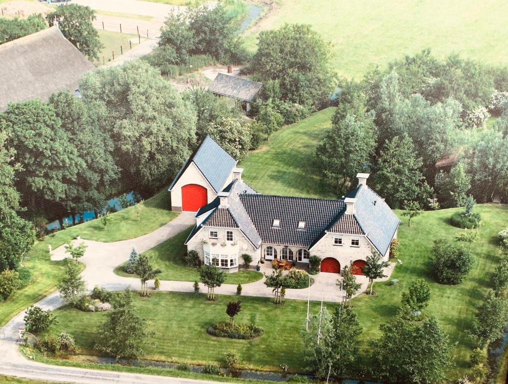 an aerial view of a house with a red barn at B&B Hoptille in Hijlaard