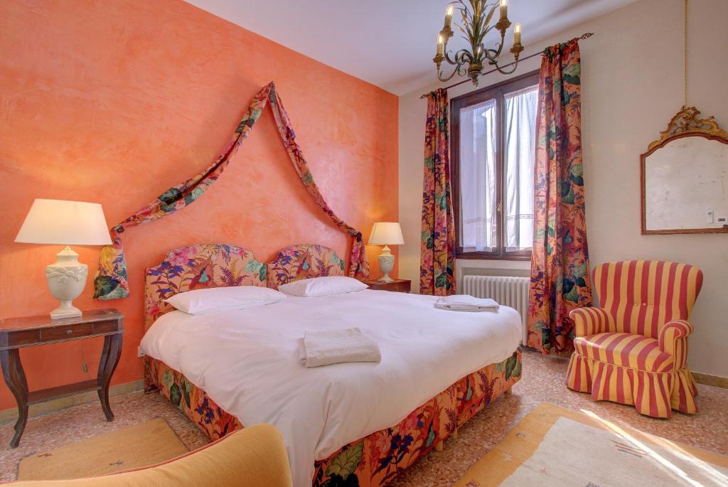 a bedroom with a large bed and a chair at BAROCCO-Veneziano in Venice