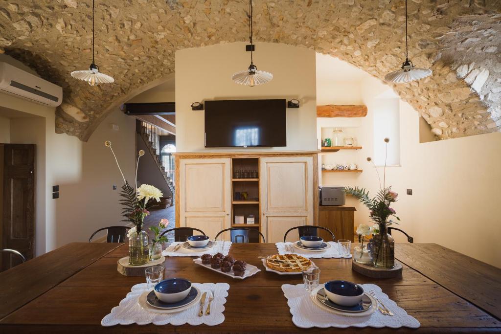 een eetkamer met een houten tafel en een televisie bij Corte Mira in Lonato