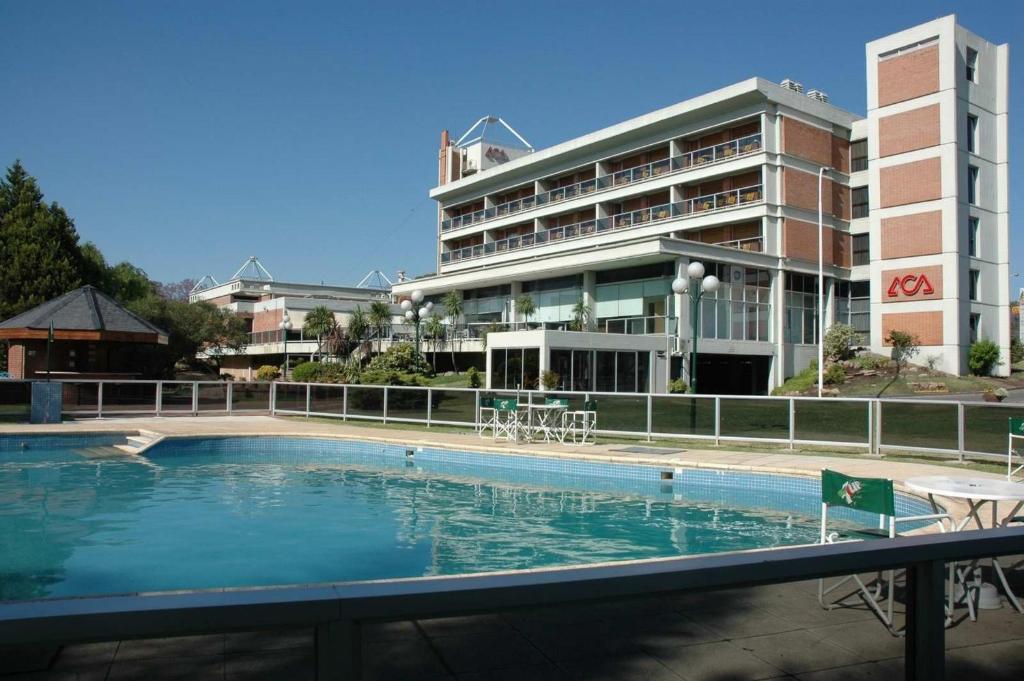
a large swimming pool in front of a large building at Hotel Dr. Cesar C. Carman in Córdoba
