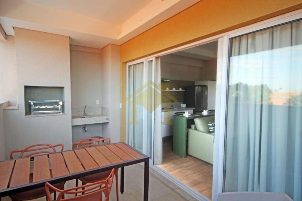 a dining room with a table and chairs and a kitchen at Hot Beach Suites in Olímpia