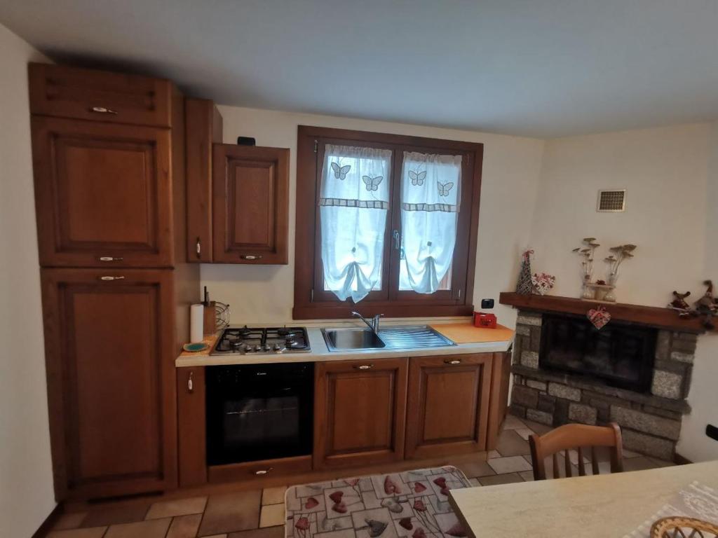 a kitchen with a sink and a stove top oven at APPARTAMENTO CORTAIOLO HOUSE in Vione