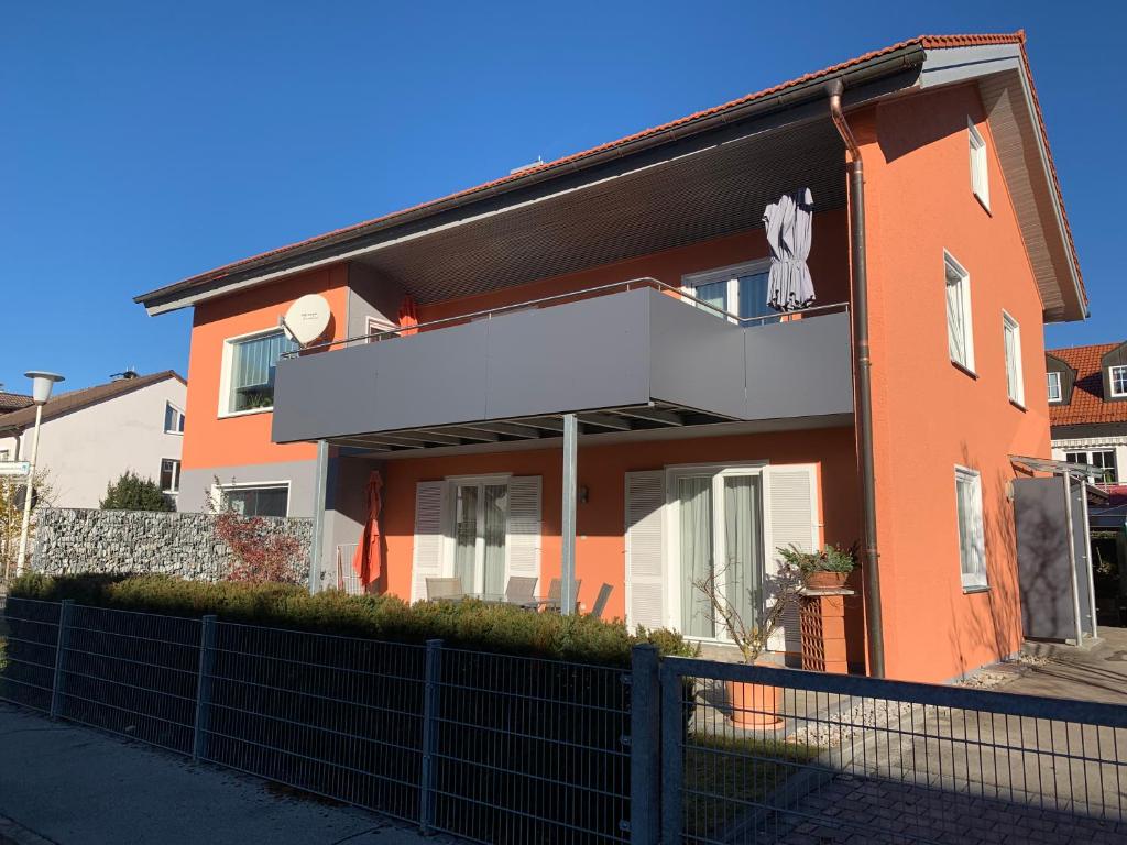 een oranje huis met een hek ervoor bij Ferienwohnung Zobl in Füssen