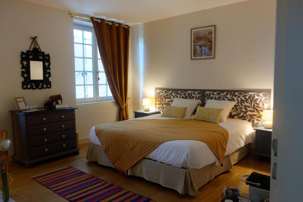 a bedroom with a bed and a dresser and a window at Bois de Cadène in Saint-Pierre-de-Buzet