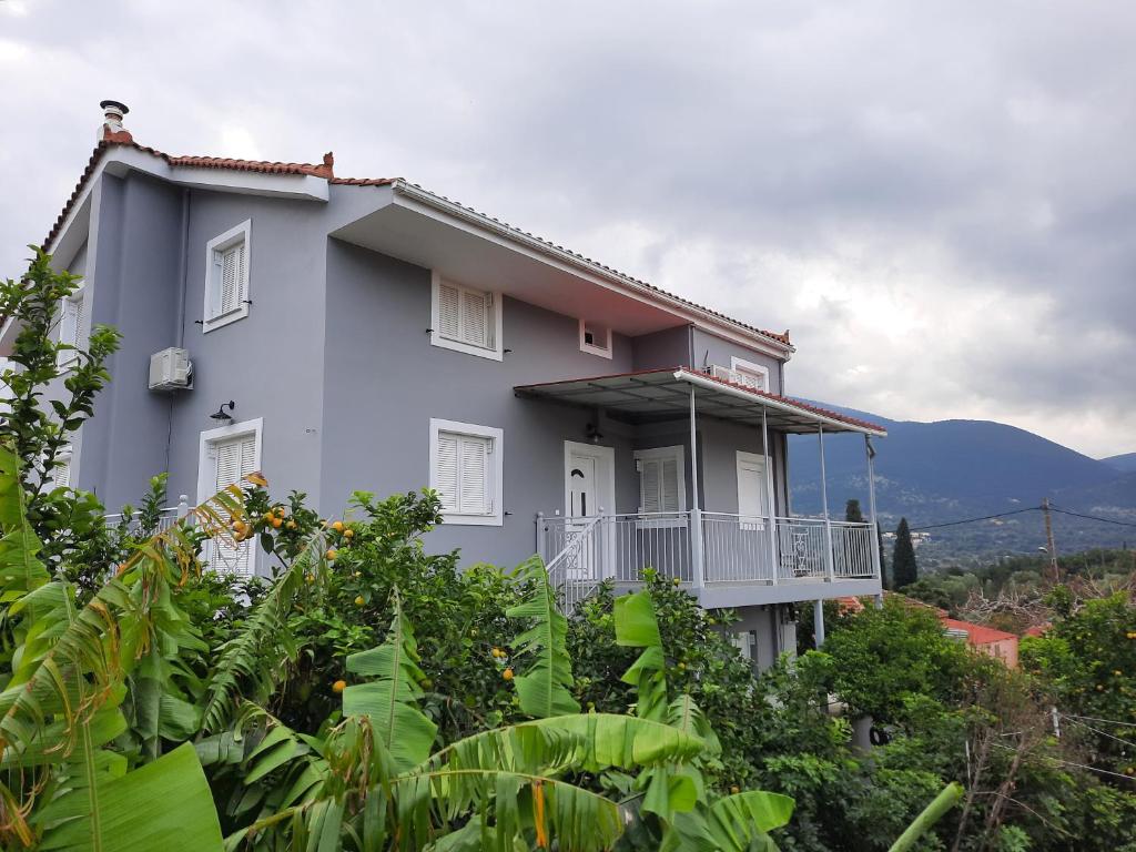 une maison blanche avec un balcon sur une colline dans l'établissement NICK & JERRY, à Céphalonie