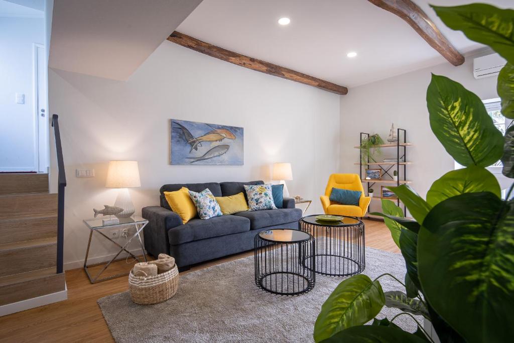 ein Wohnzimmer mit einem blauen Sofa und 2 Tischen in der Unterkunft Casa de Santa Rita in São Roque