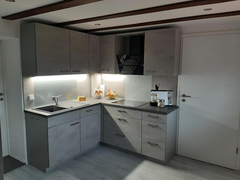 a kitchen with white cabinets and a sink at Ferienhaus Schmalkalden in Schmalkalden