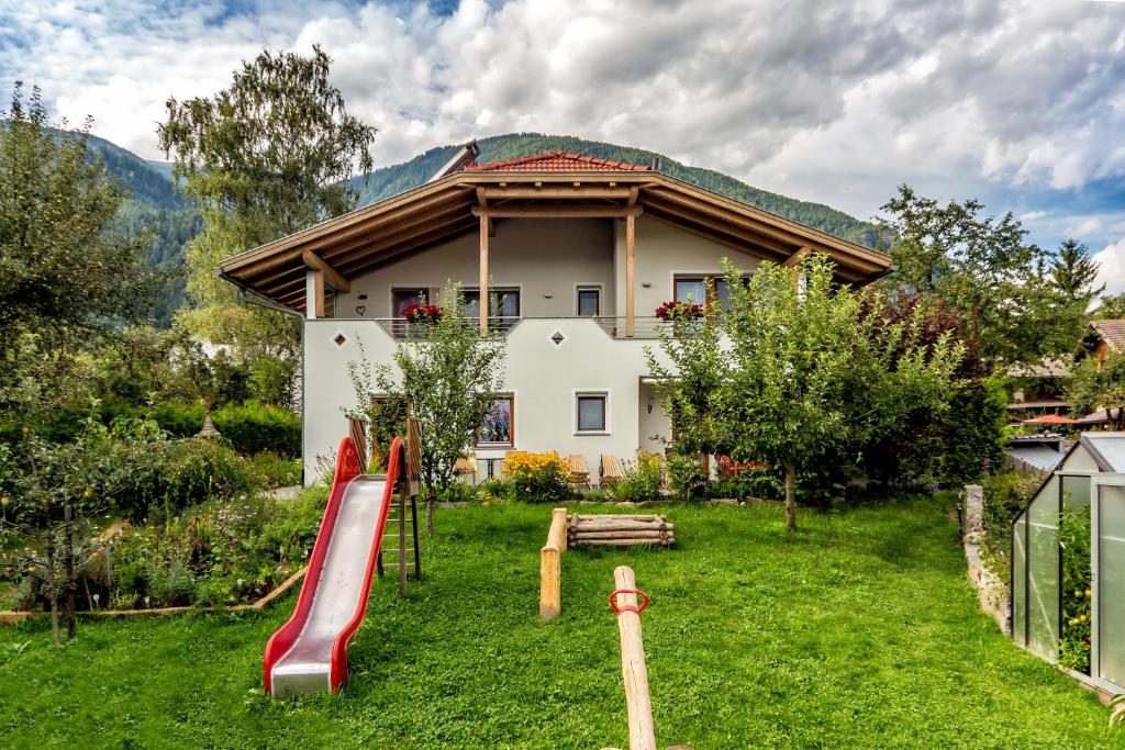 ein Haus mit einem Spielplatz vor einem Hof in der Unterkunft Lampenhof in Bruneck