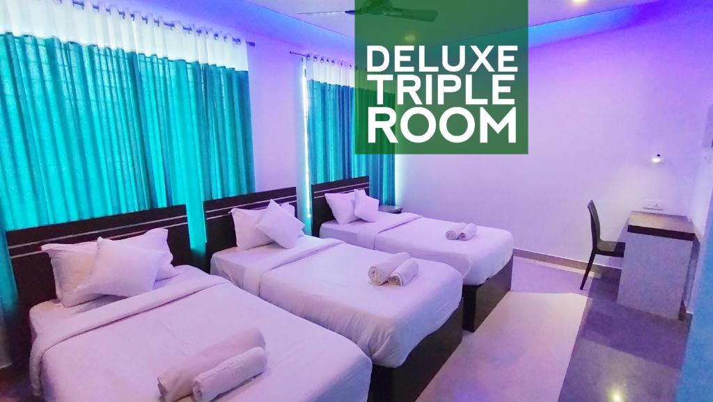 a hotel room with three beds and the words deliver triple room at Railview Residency in Alleppey