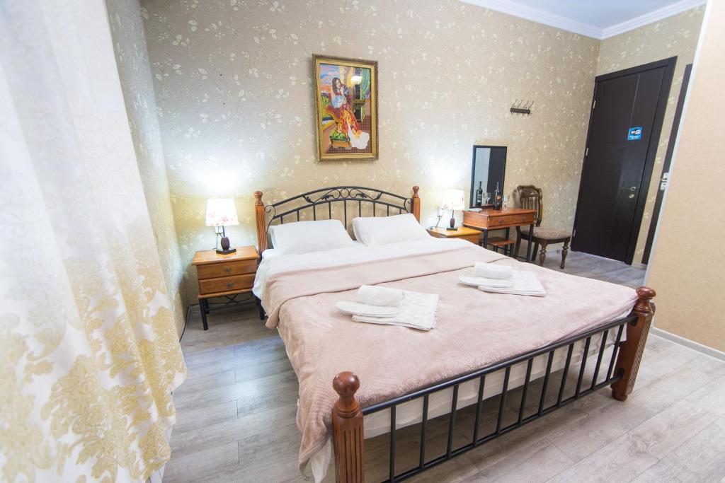 a bedroom with a bed with two towels on it at Terrace House Near Opera in Tbilisi City