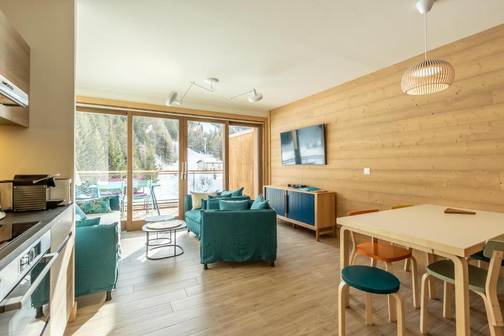 阿爾克1600的住宿－LE RIDGE Résidence Premium - Les Arcs Paradiski，厨房以及带桌椅的起居室。