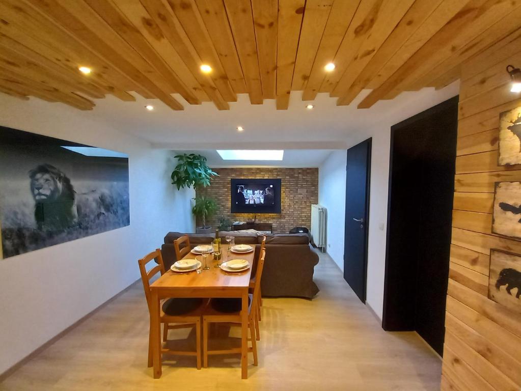 a dining room and living room with a table and chairs at Entre Nature Et Circuit in Francorchamps