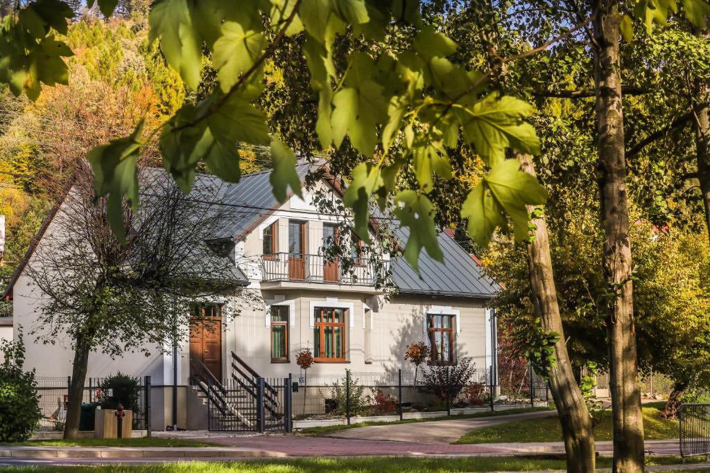 a white house with a black roof at Villa 124 SPA & Sauna komfortowy apartament Beskidy in Bystra