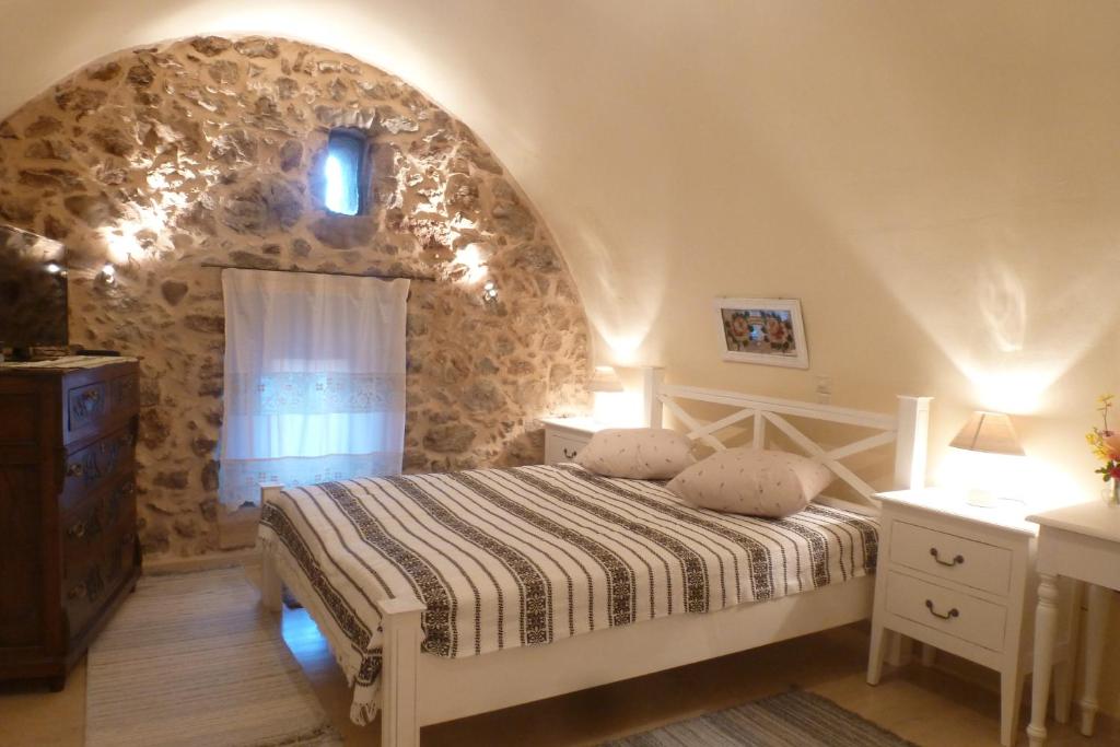 um quarto com uma cama e uma parede de pedra em To Petradi em Avgonyma