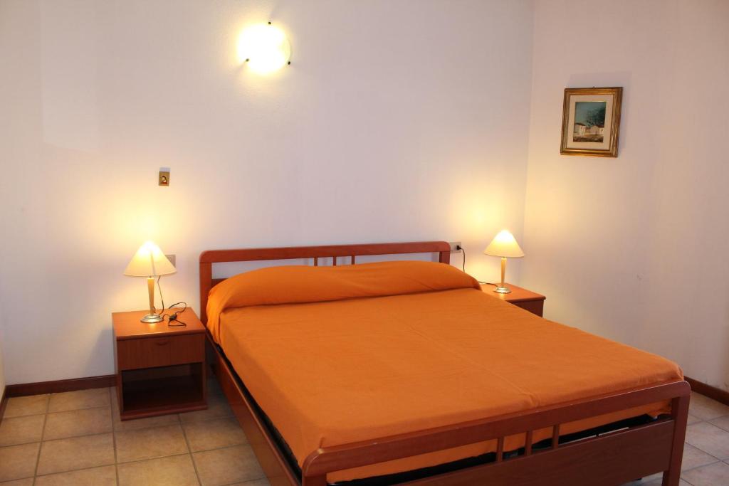 sypialnia z pomarańczowym łóżkiem i 2 lampami w obiekcie Casa San Pasquale panoramica e tranquilla w mieście San Pasquale