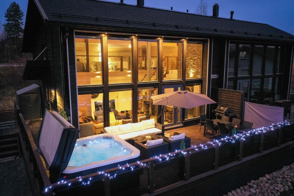 een huis met een hot tub in de achtertuin met verlichting bij Villa Halla - 8 henkilölle, HimosYkkösen alue, 76m²+36m² in Jämsä