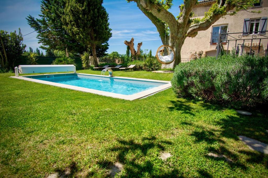 a swimming pool in the yard of a house at Gîte de Valentin Moulin de Tartay en Avignon in Avignon