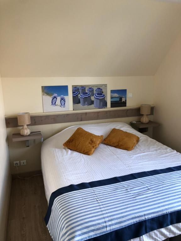 um quarto com uma cama com duas almofadas em Maison Fort-Mahon Plage Residence Belle Dune em Fort-Mahon-Plage