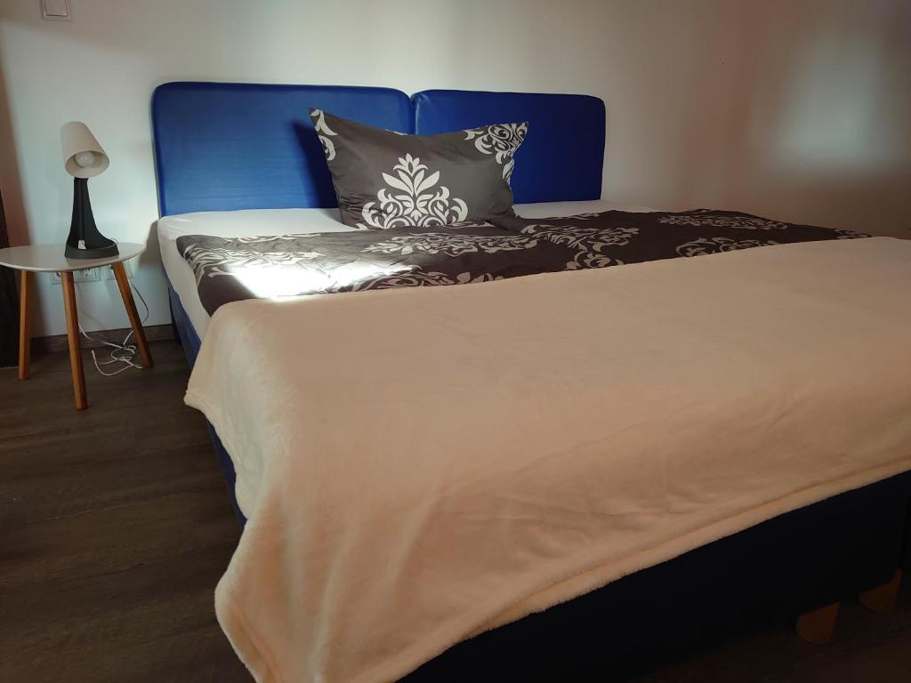 een slaapkamer met een bed met een blauw hoofdeinde bij Haus No. 5A in Demmin