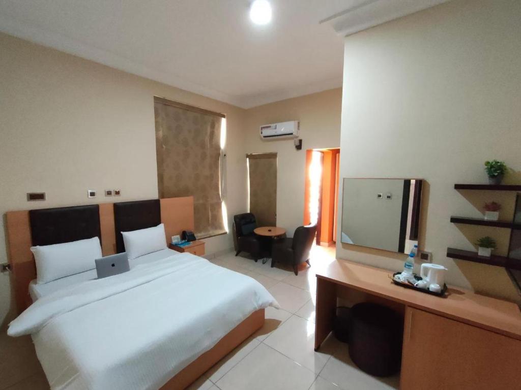 Habitación de hotel con cama y TV en AYAAKAJE GUEST HOUSE, en Ibadán