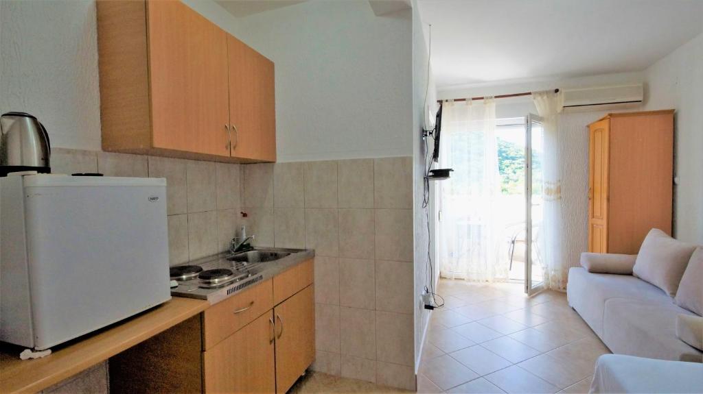 a kitchen with a white refrigerator and a couch at MM Apartments in Budva