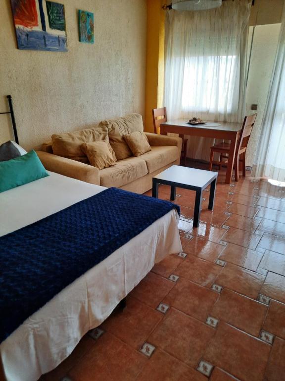 een woonkamer met een bed, een bank en een tafel bij Apartamento Sonia in Torremolinos