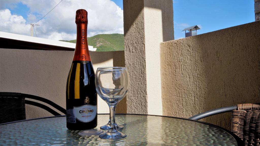 a bottle of wine sitting on a table with a glass at MM Apartments in Budva