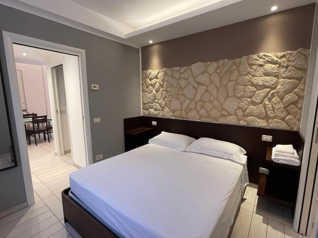 Un dormitorio con una cama grande con una pared de piedra. en Al Piano 2, en Ancona