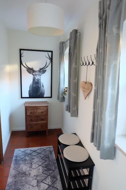 una habitación con dos taburetes y una foto de un ciervo en la pared en Ferienwohnung Stöckl, en Grabenstätt