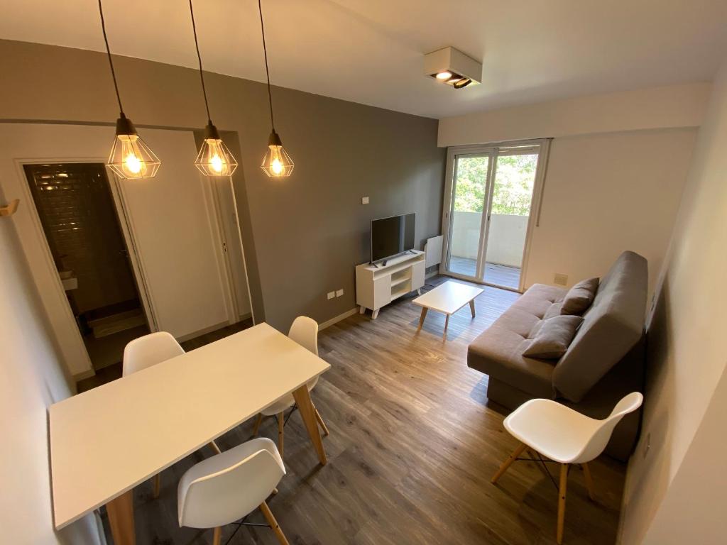 a living room with a table and a couch at Buenaventura Apartments PARQUE in Mendoza