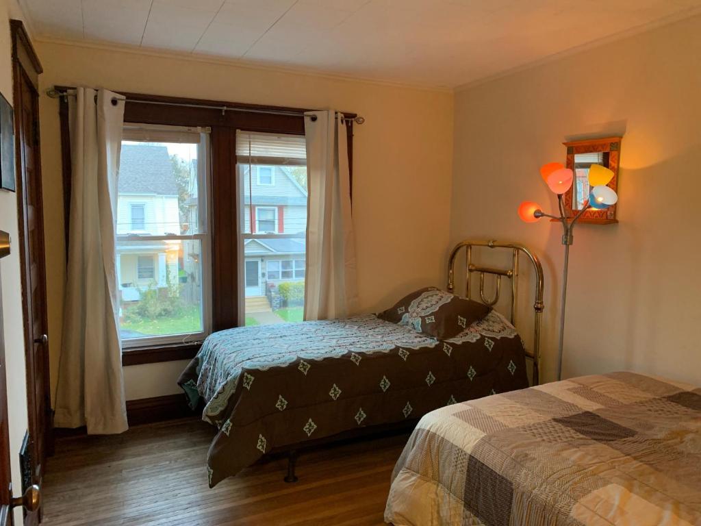 um quarto com 2 camas e uma grande janela em Wanderfalls Guesthouse & Hostel em Niagara Falls