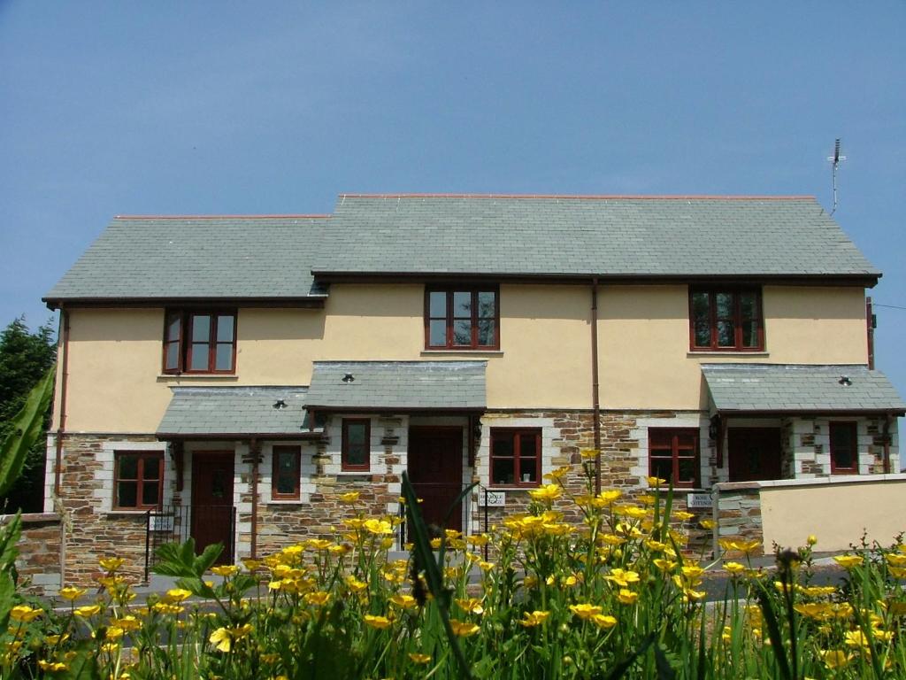 an old house with yellow flowers in front of it at Rose Cottage in Camelford