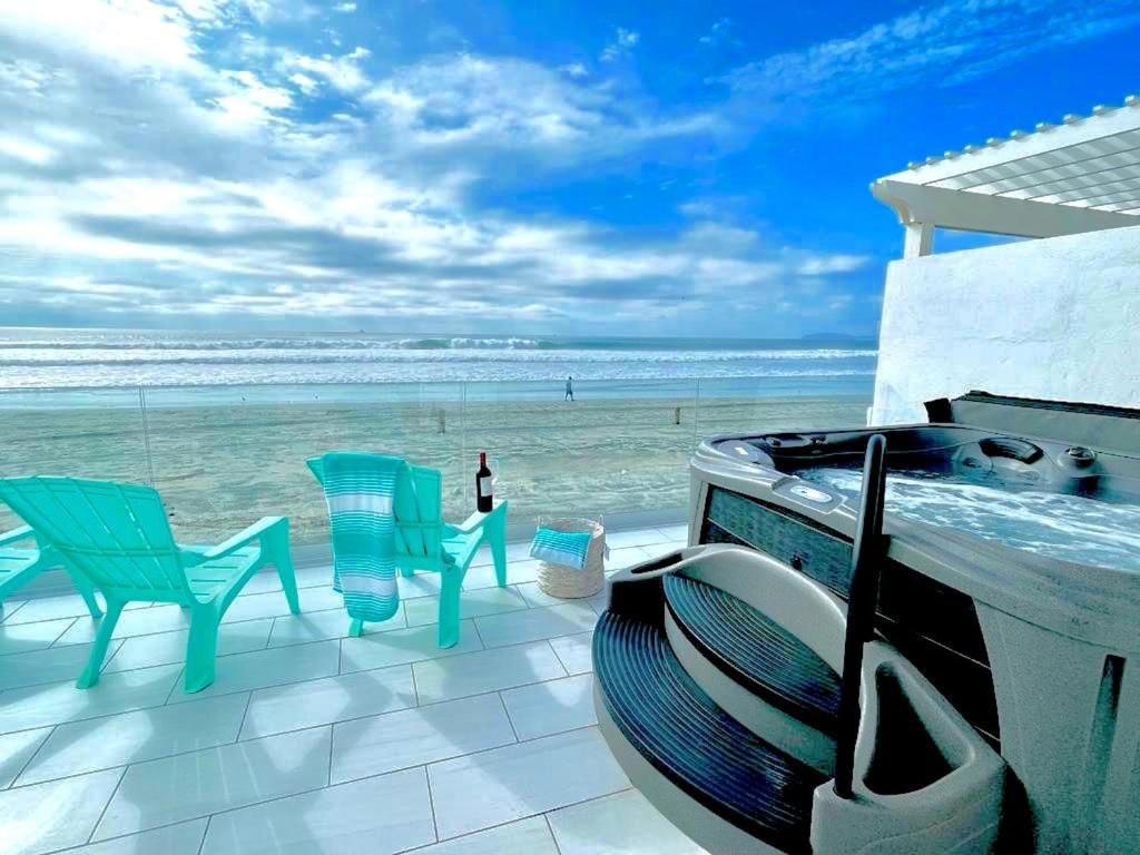 a view of the beach with chairs and a grill at Quinta Pacifica Beachfront Villas in Rosarito