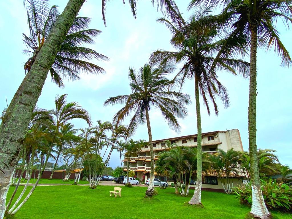 a park with palm trees and a building at Leviv Praia Hotel in Caraguatatuba