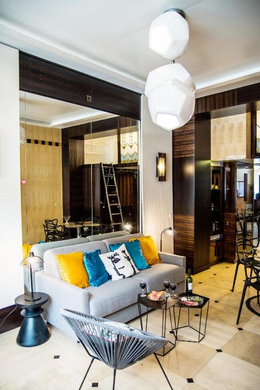 un salon avec un canapé et quelques tables dans l'établissement Studio boisé à 2 pas du jardin du Luxembourg, à Paris